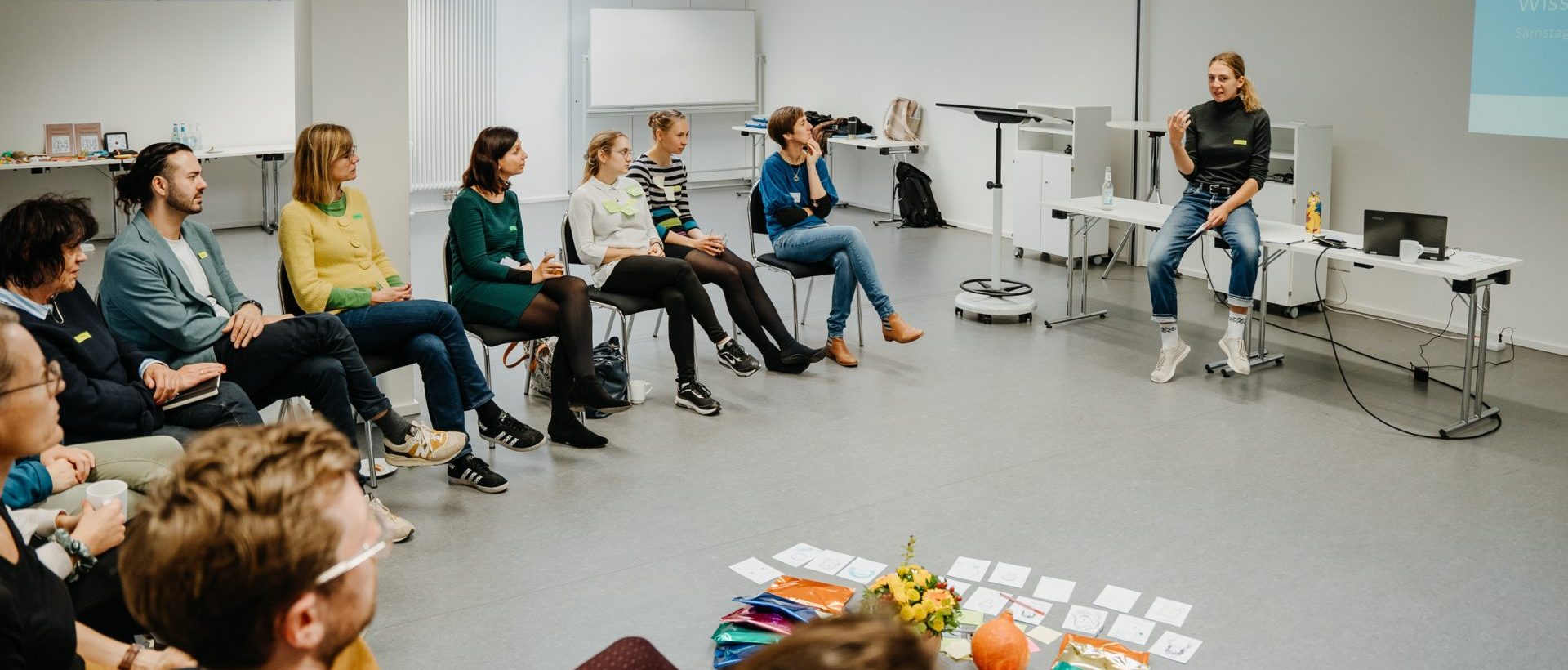 Workshopsituation: Mehrere Menschen sitzen in einem Stuhlreis. Foto: Reimann Fotografen / Alexander Reime